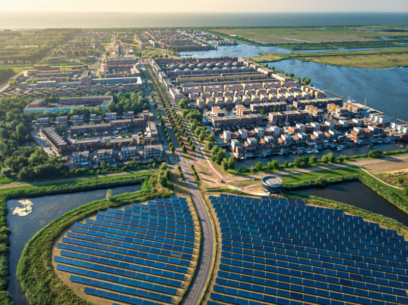 Modern sustainable neighbourhood in Almere, The Netherlands. The city heating (stadswarmte) in the district is partially powered by a solar panel island. Aerial view.