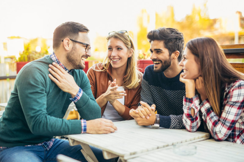 group of people talking at table outside