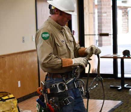 A lineman performing a safety demonstration 